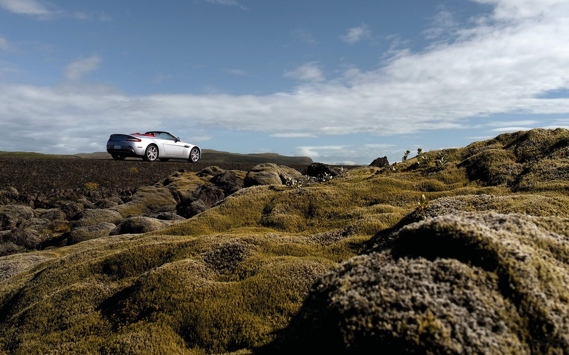 Silver car on mossy landscape