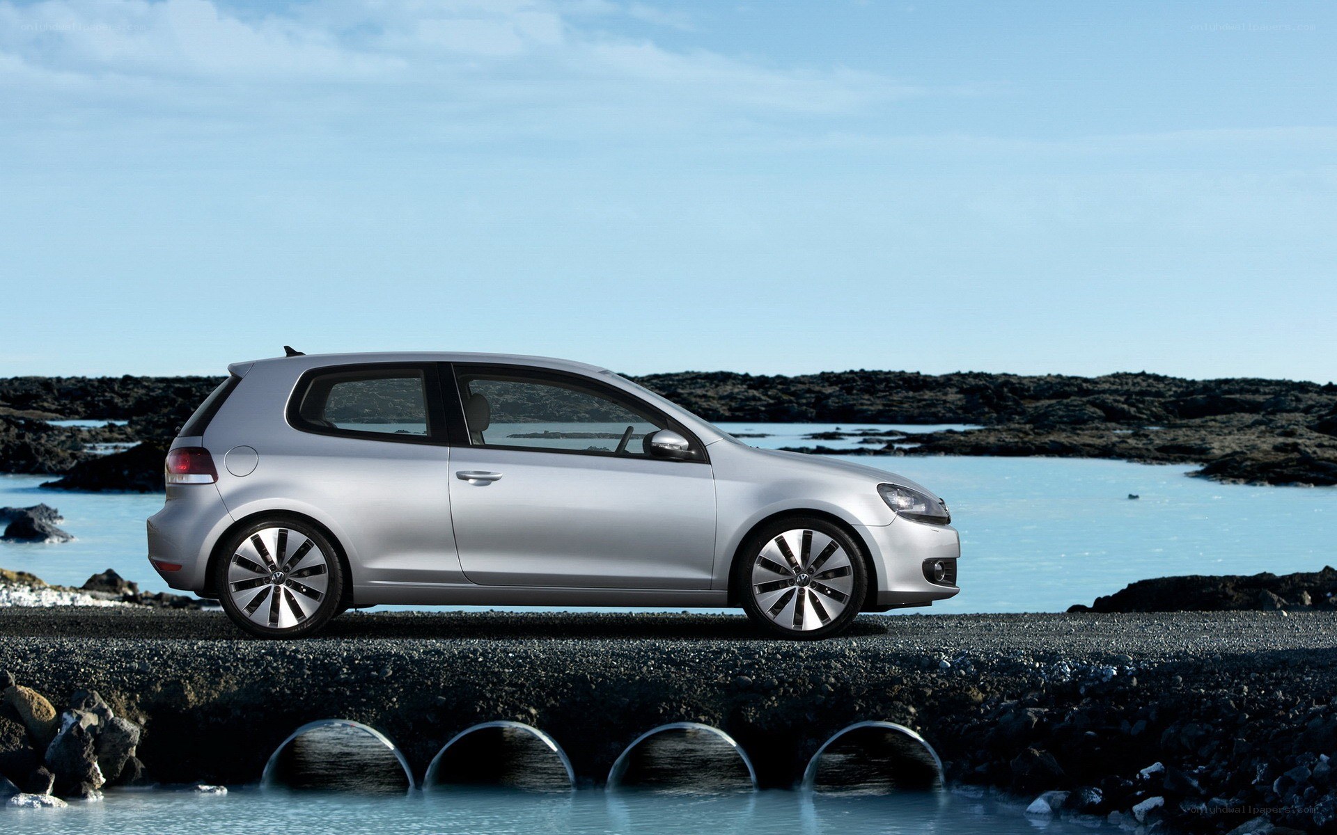 Silver car on rocky shore