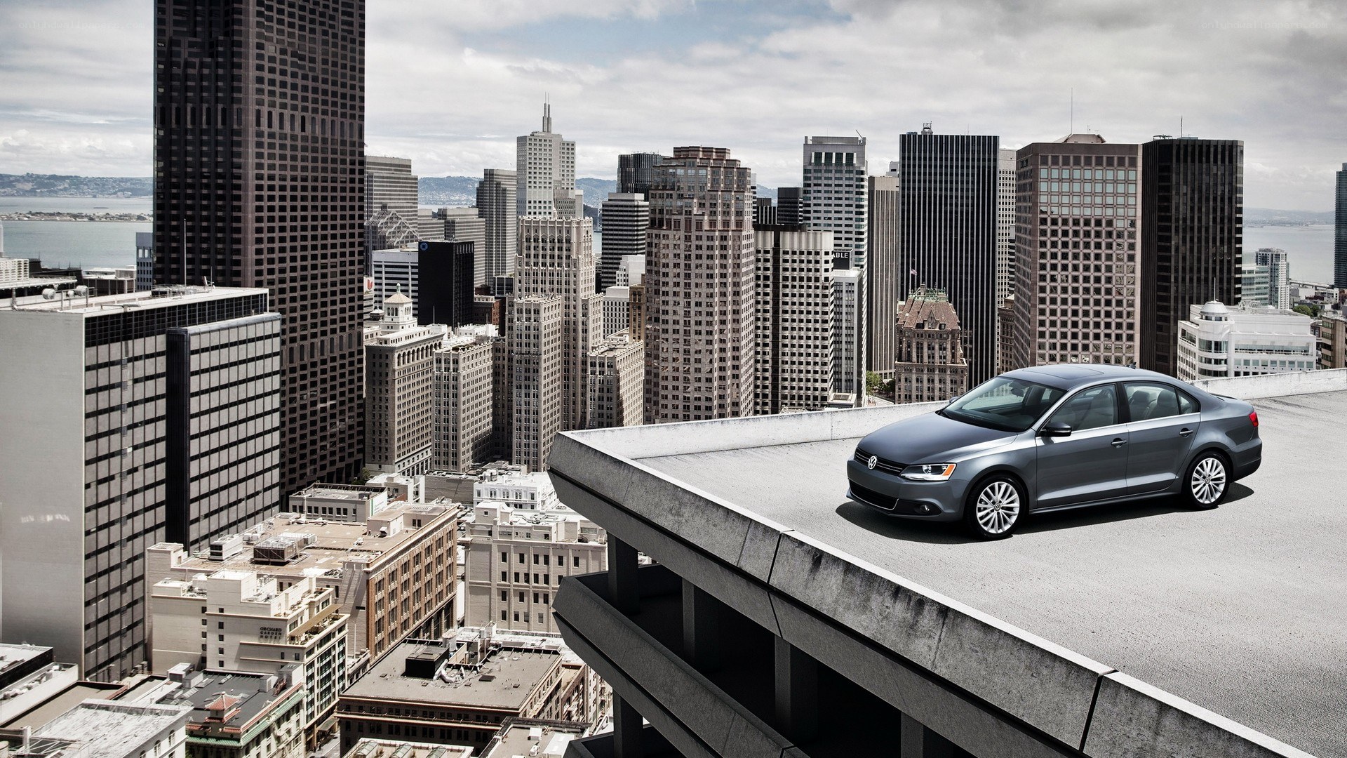 Silver car on rooftop with city view