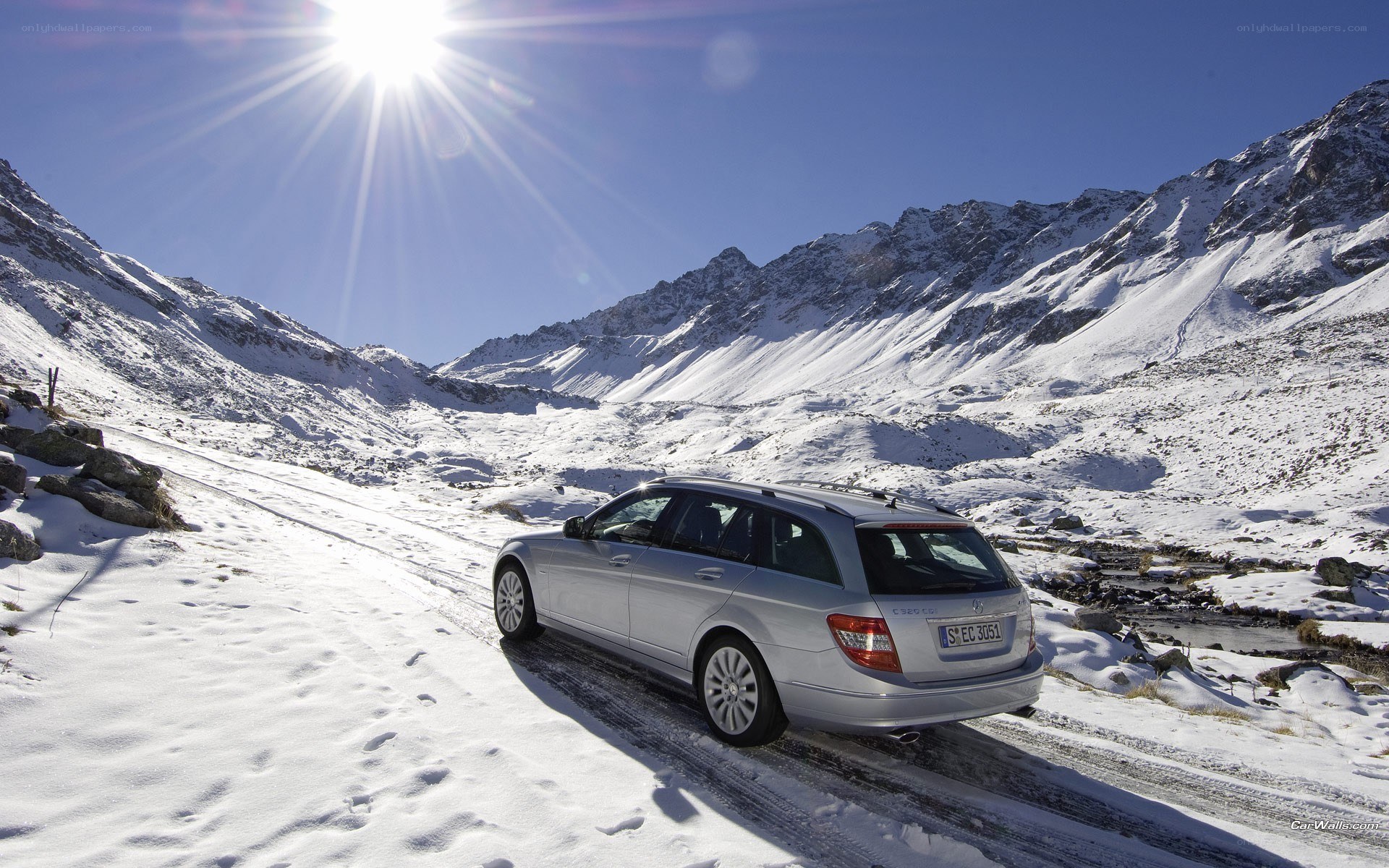 Silver car on snowy mountain road