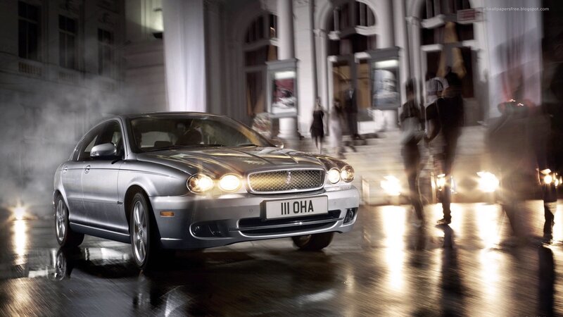Silver car on wet street at night