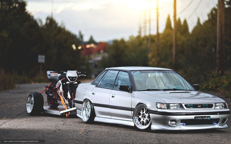 silver car towing motorcycle