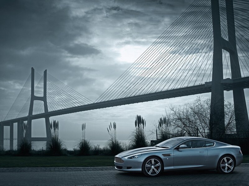 Silver car under a cable-stayed bridge