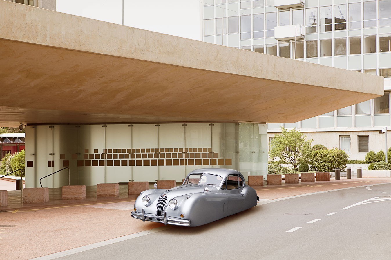 Silver car under modern building