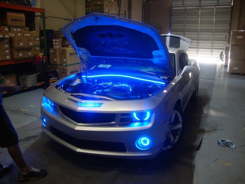 Silver car with blue lights in garage