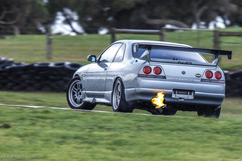 silver car with flames from exhaust