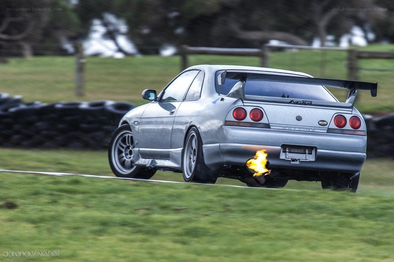 silver car with flames from exhaust