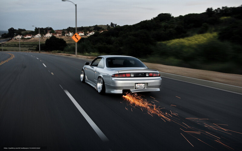 Silver car with sparks on road