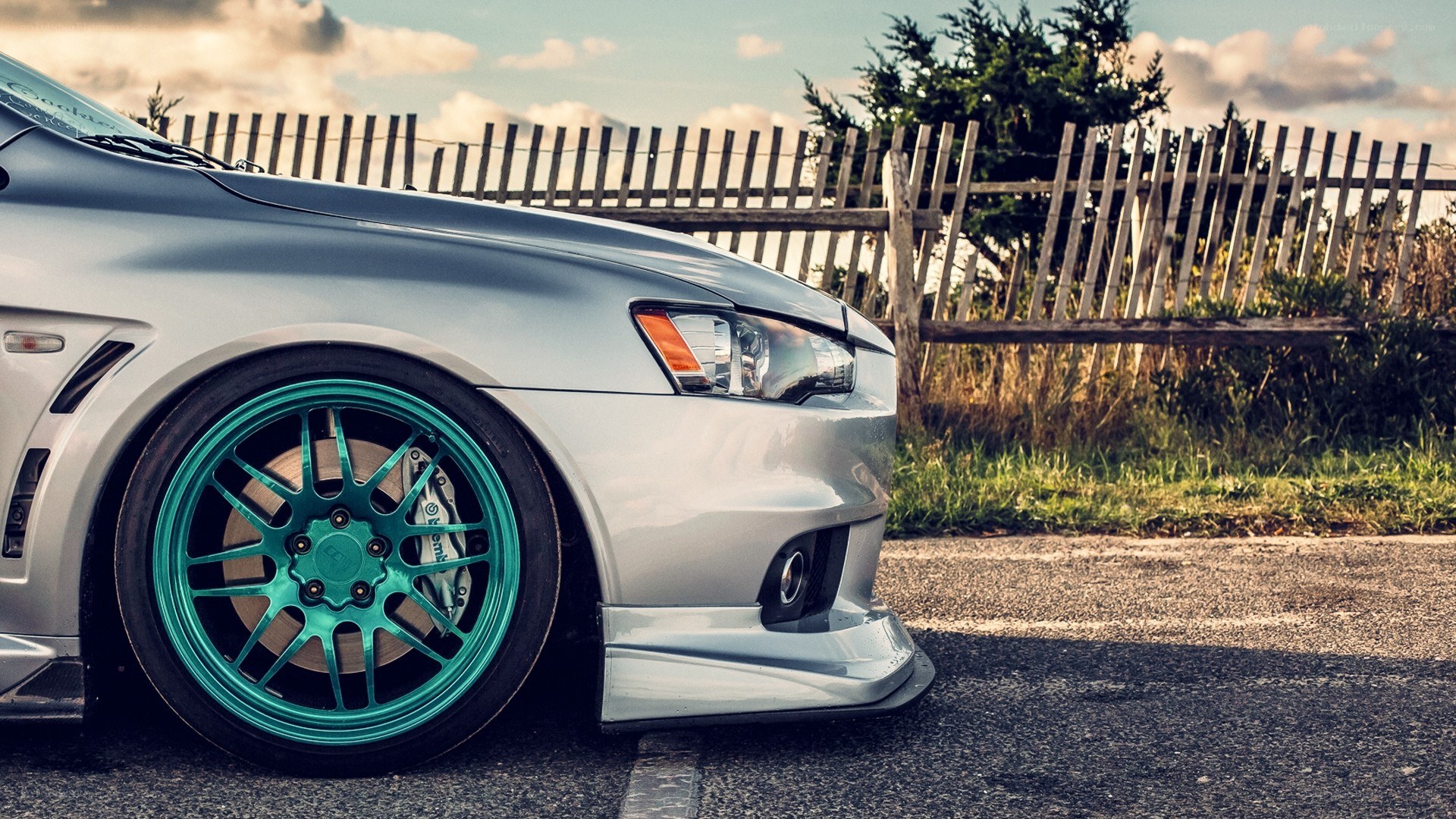 silver car with teal wheels