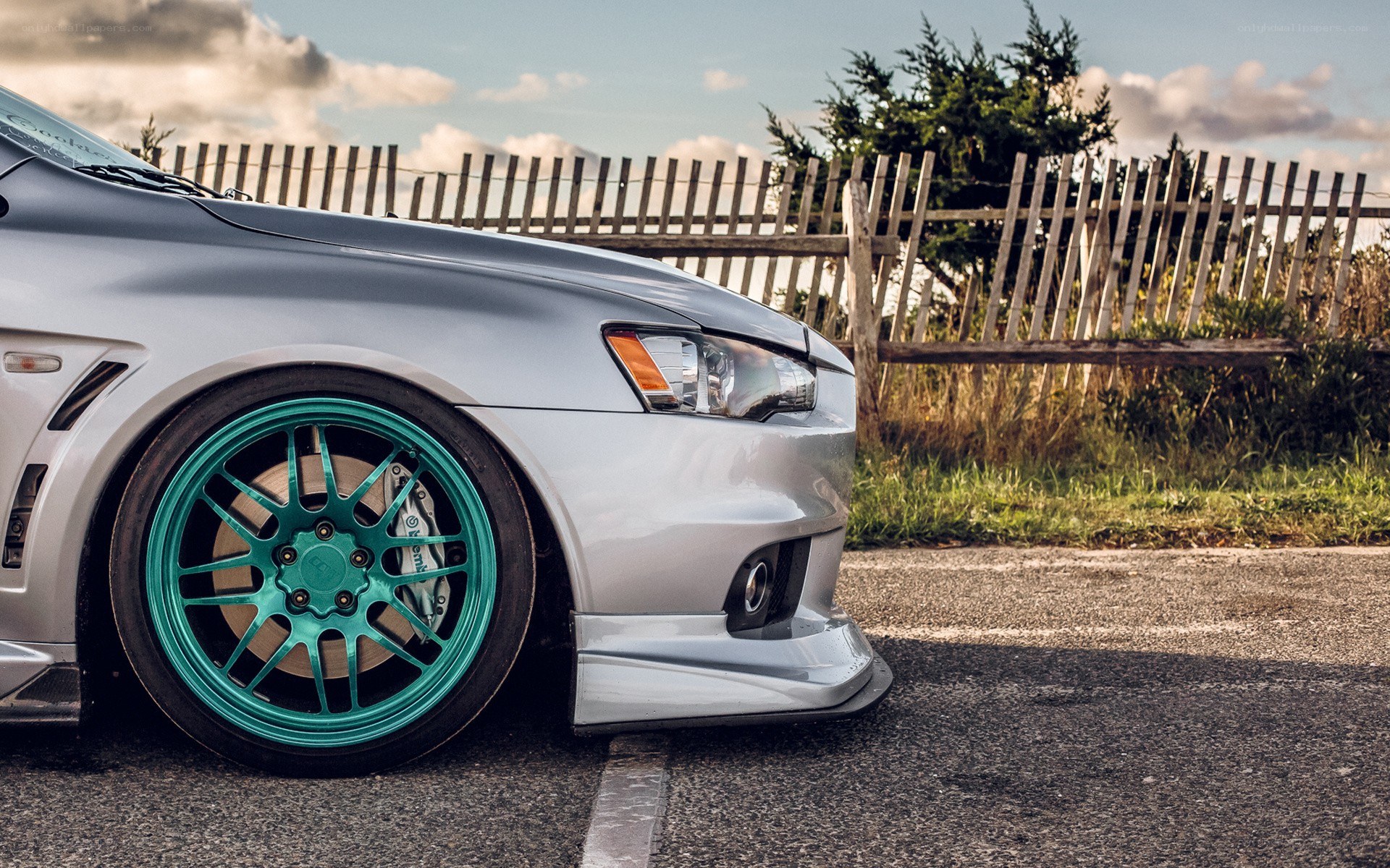 silver car with teal wheels