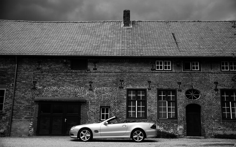 Silver convertible by brick building
