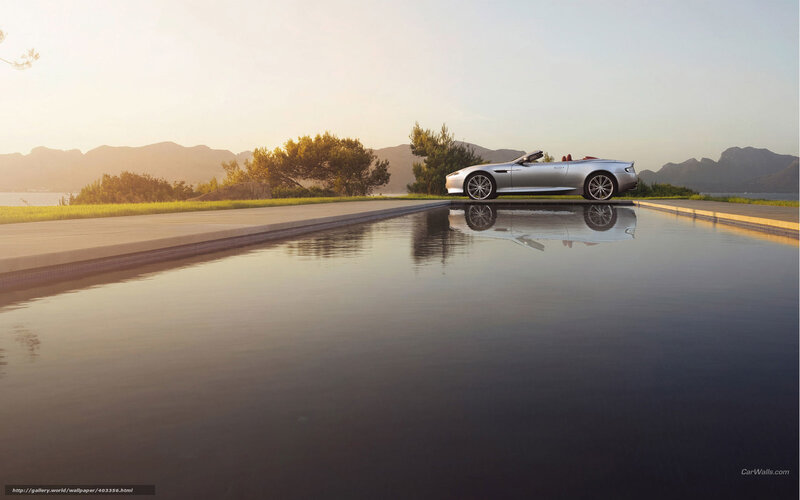 Silver convertible by pool at sunset