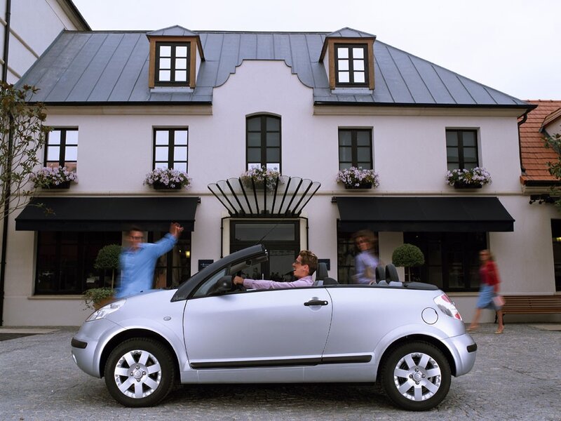 Silver convertible car in front of building