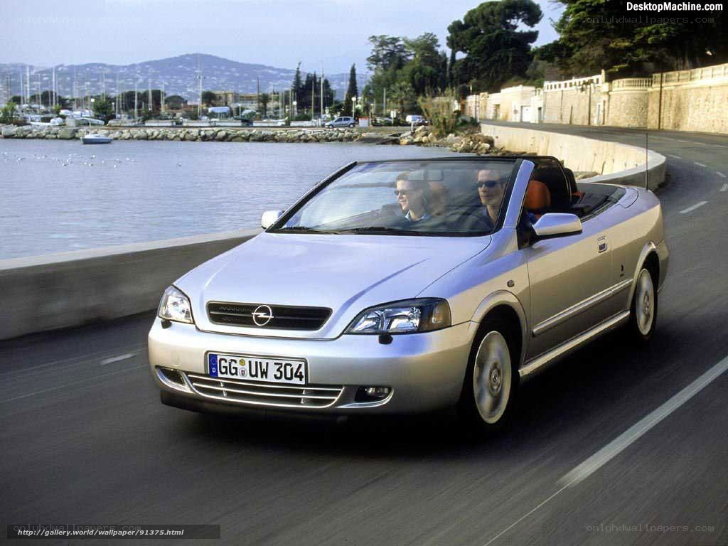 silver convertible driving by water