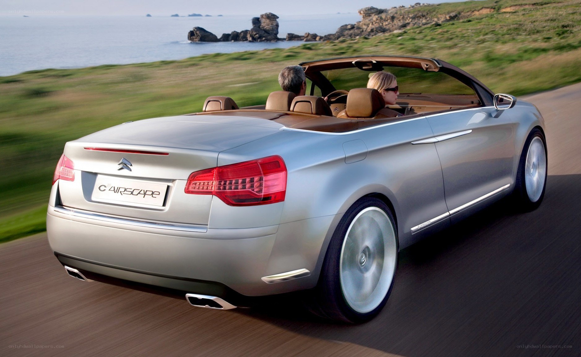 Silver convertible driving on coast