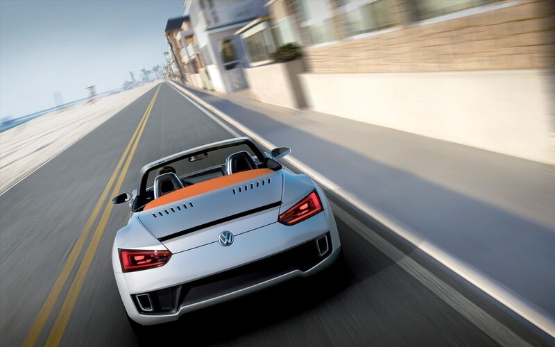 Silver convertible driving on coastal road