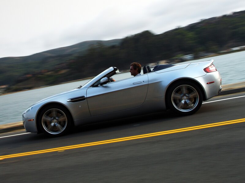 silver convertible driving on coastal road