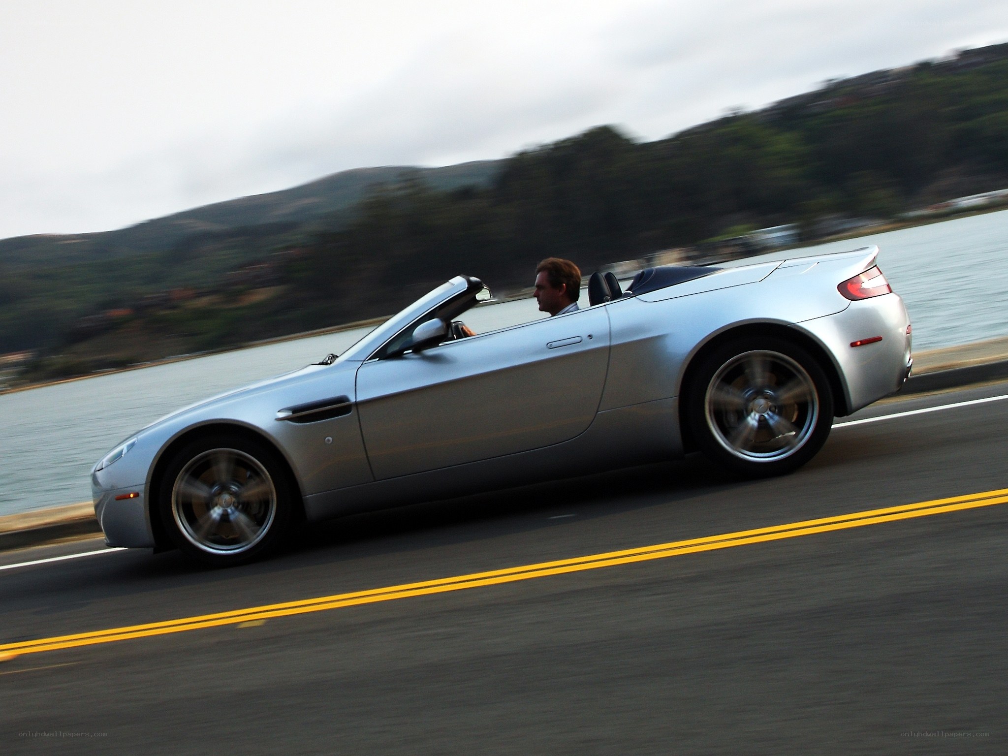 silver convertible driving on coastal road