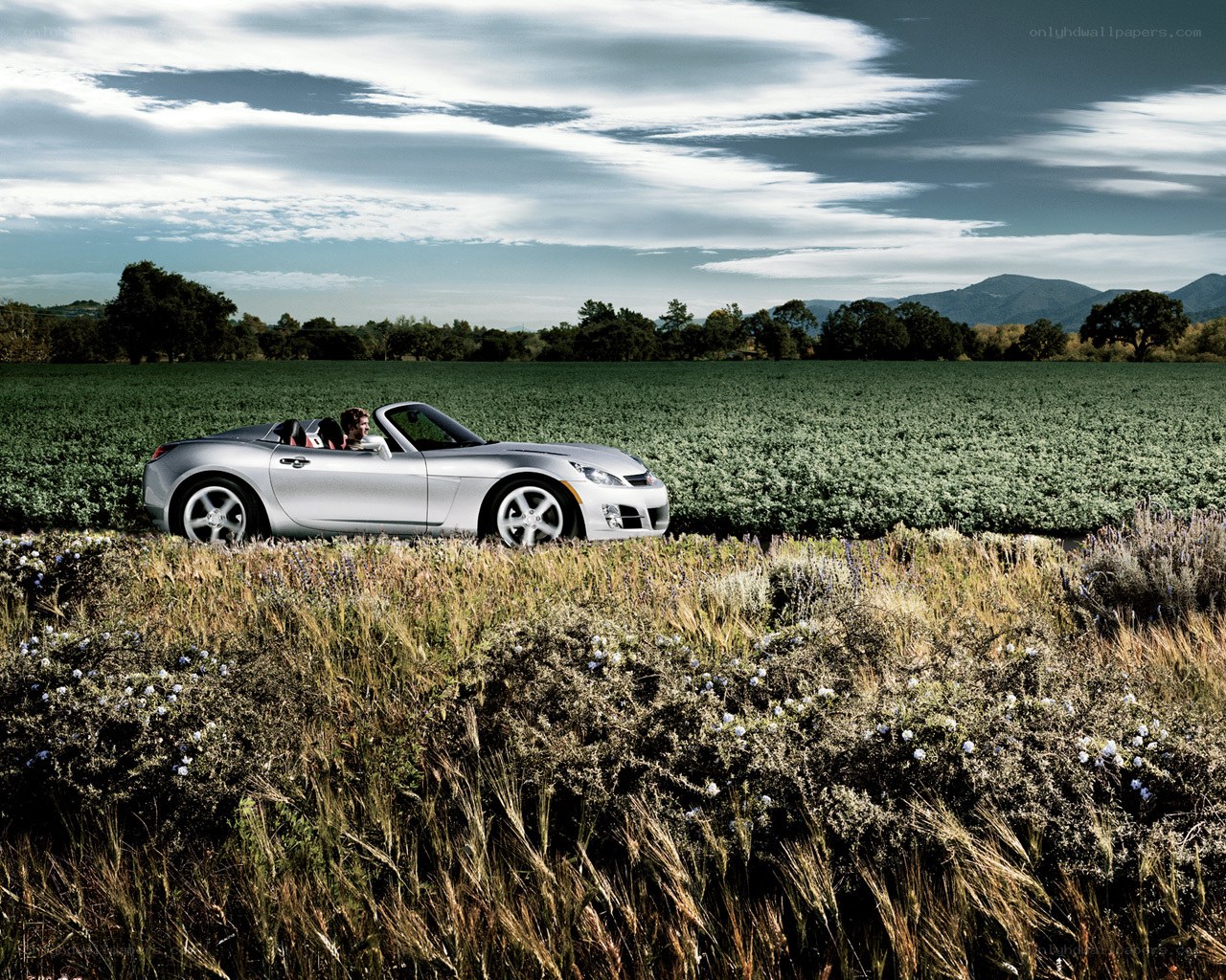 Silver convertible on a country road
