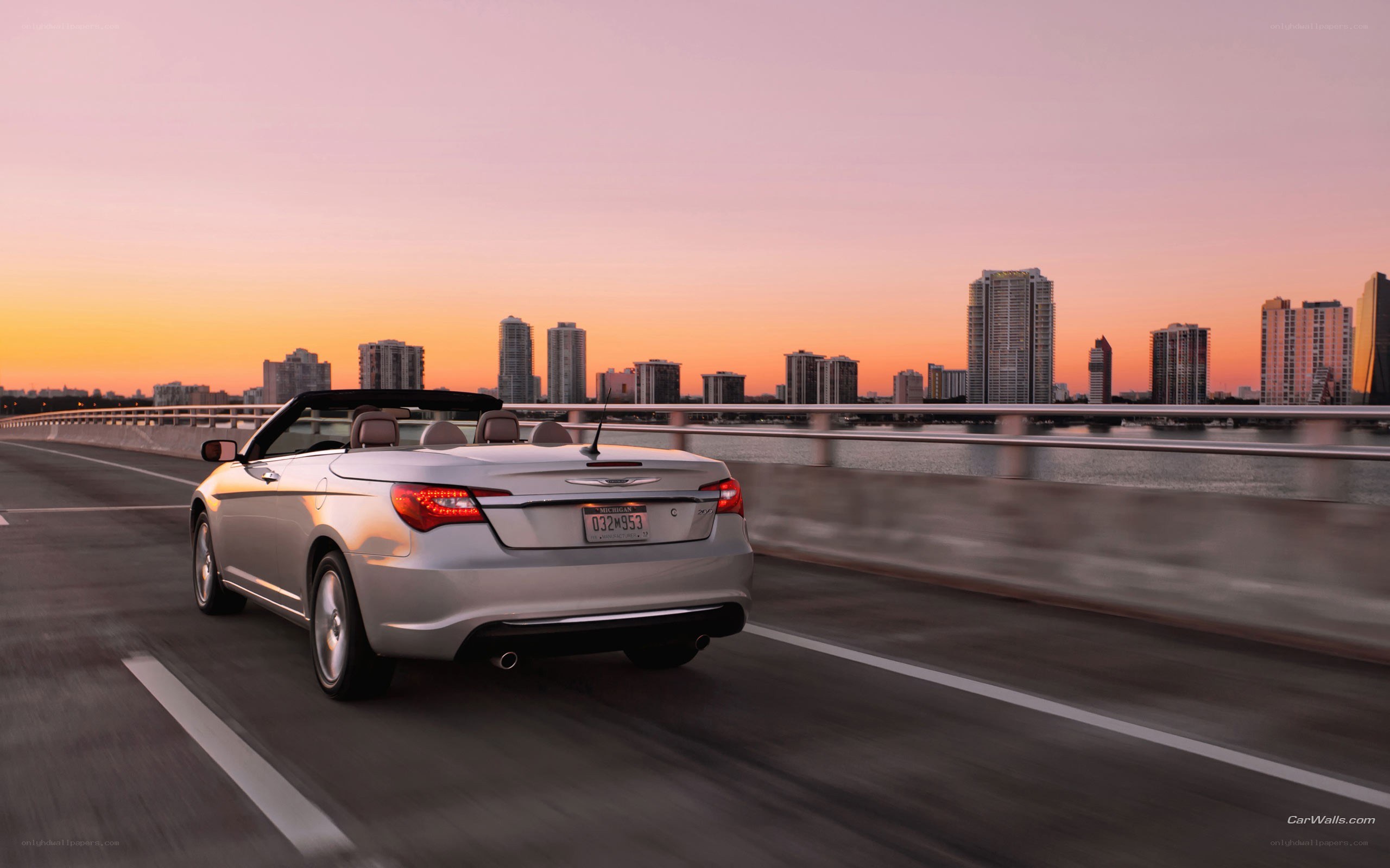 silver convertible on bridge at sunset