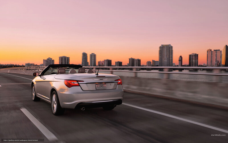 Silver convertible on bridge at sunset