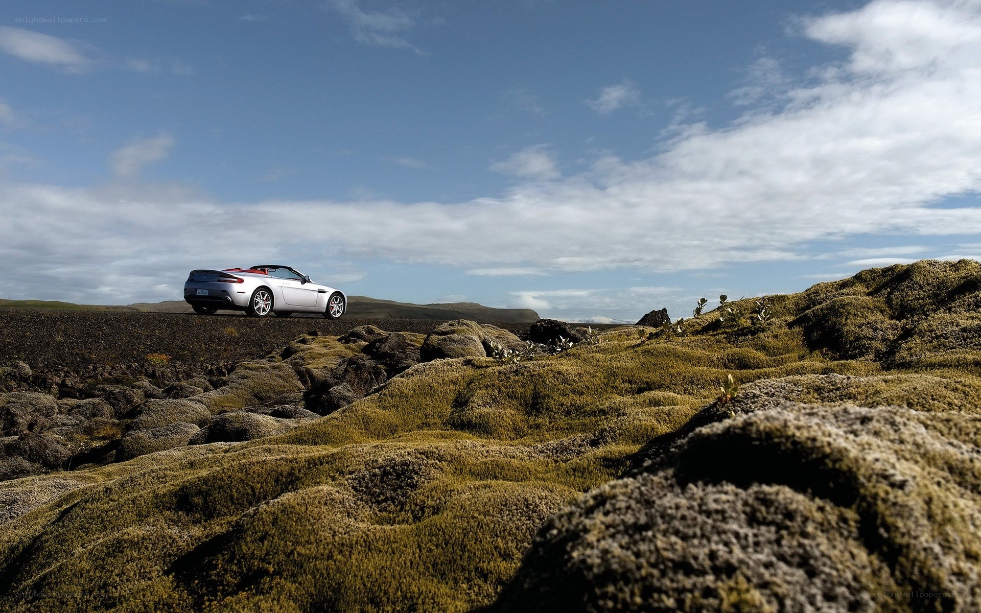 Silver convertible on mossy terrain