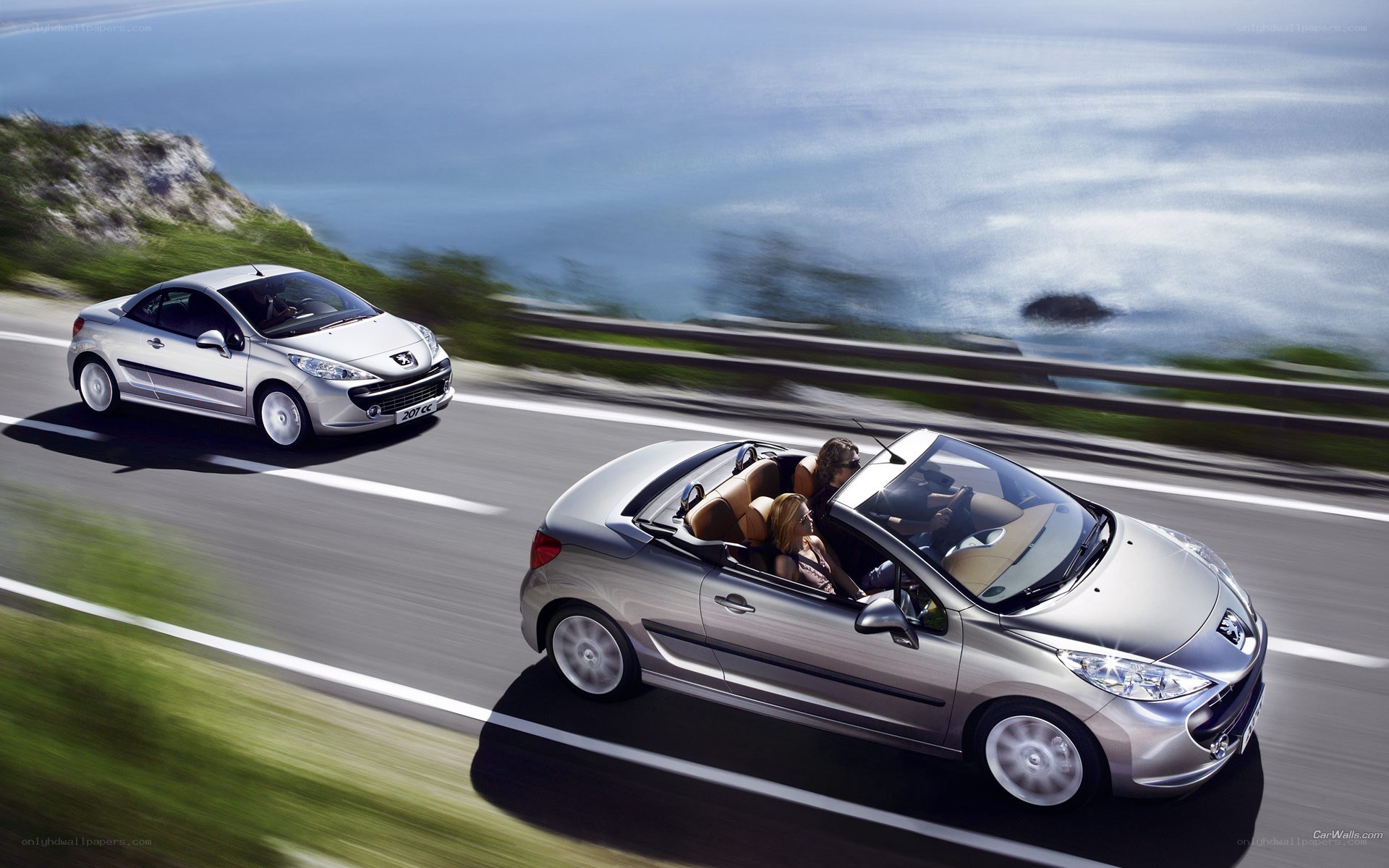Silver convertibles on coastal road