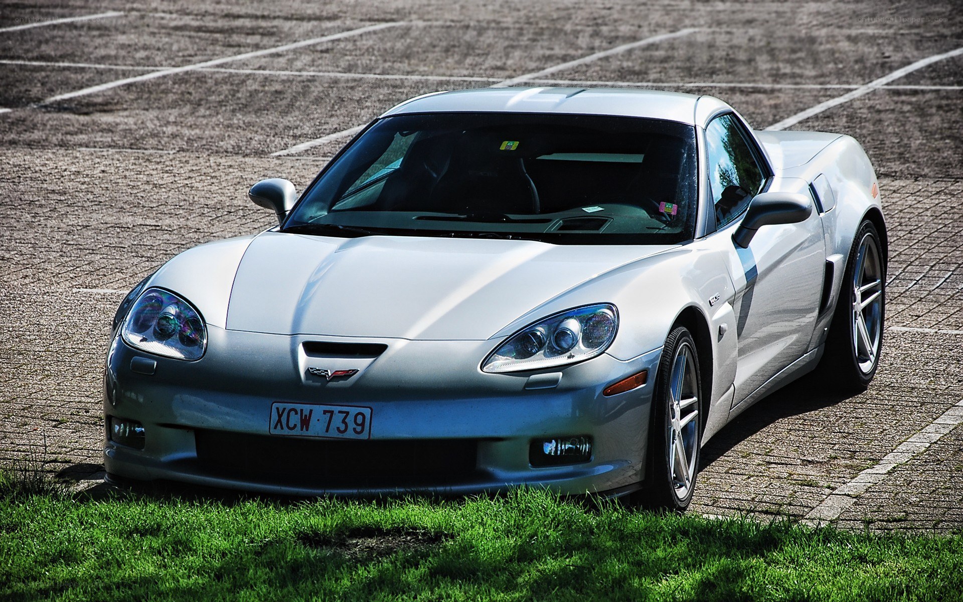 silver corvette parked in lot