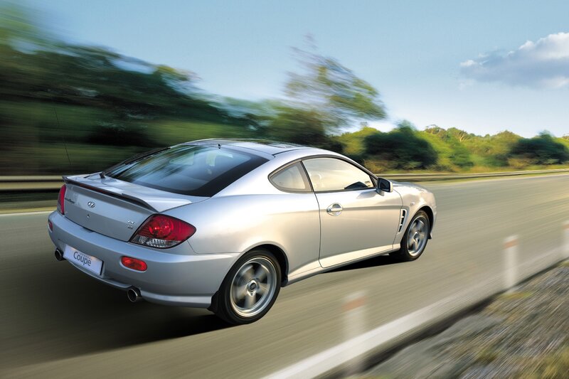 Silver coupe in motion on road