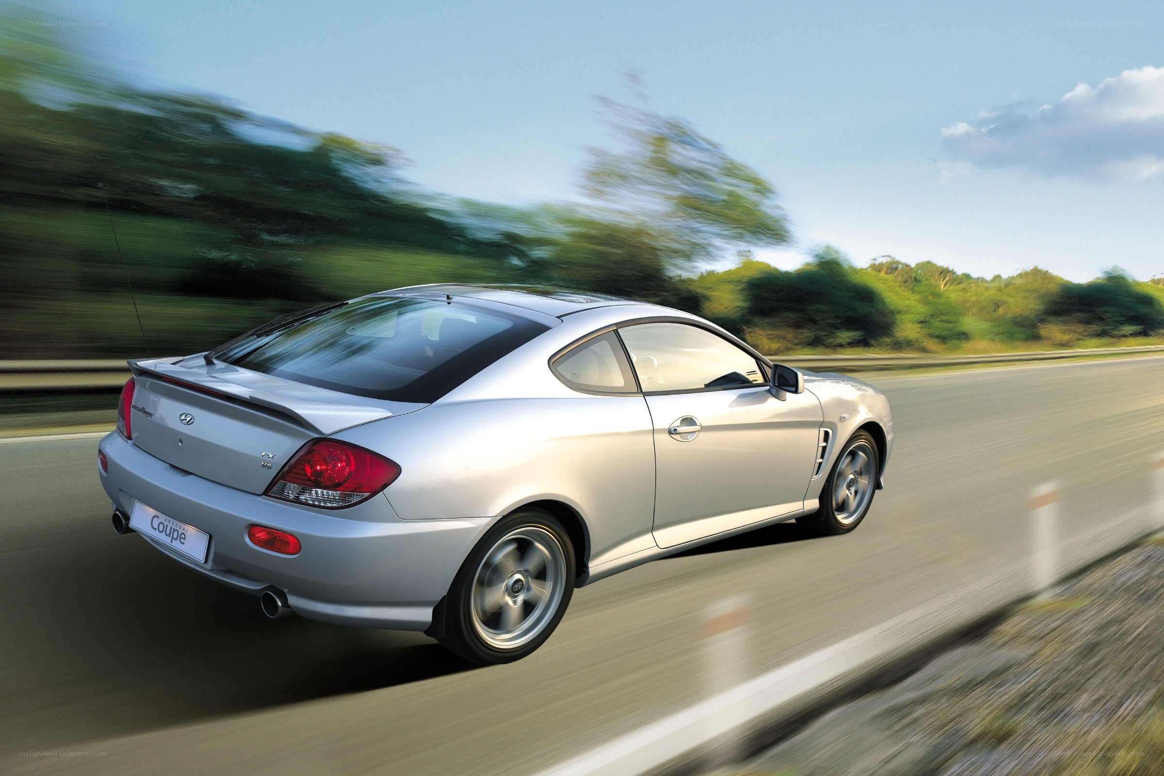 Silver coupe in motion on road