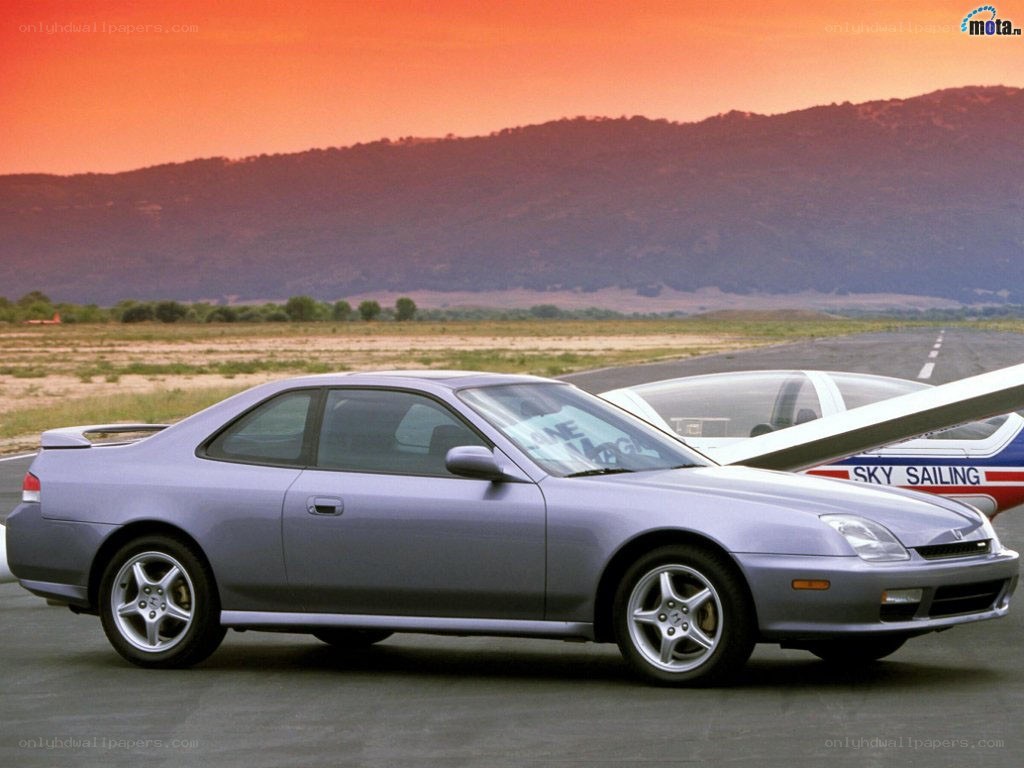 Silver coupe on airfield at sunset
