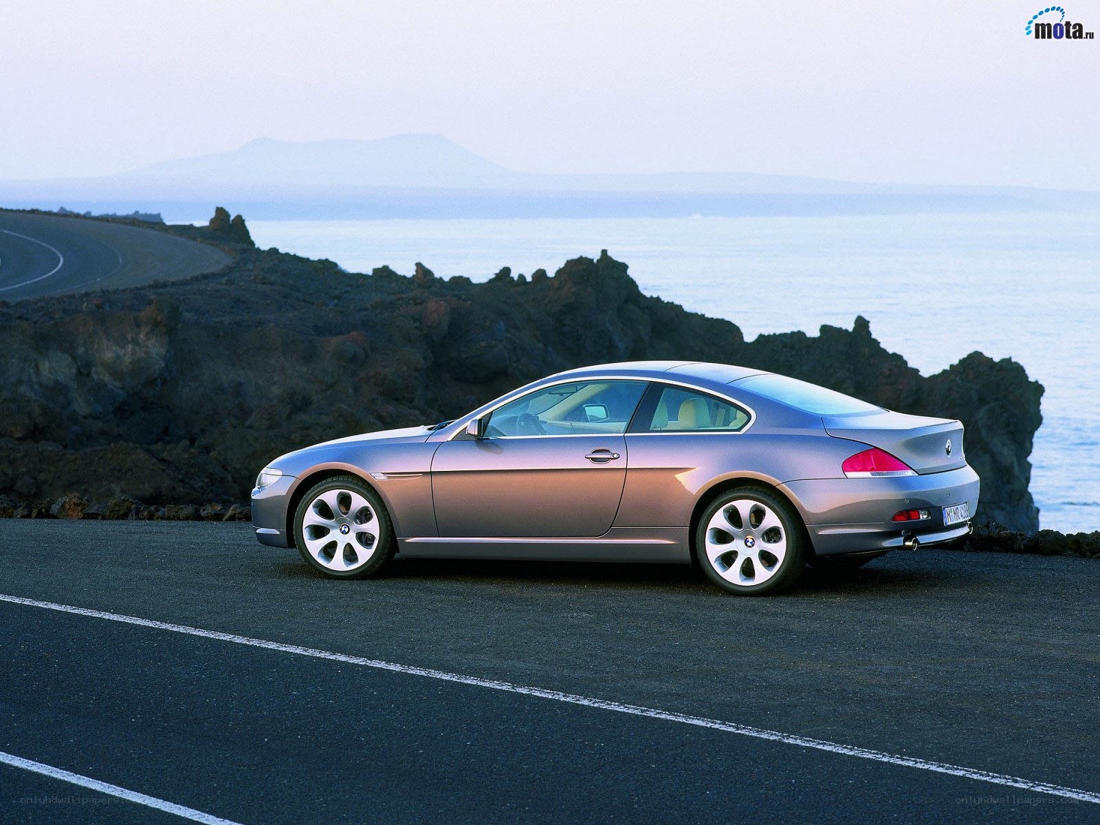 silver coupe on coastal road