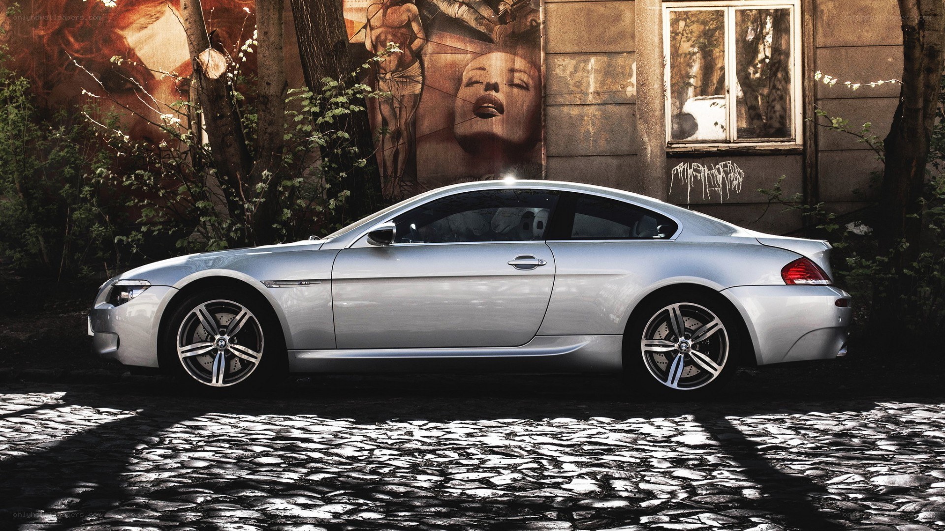 silver coupe on cobblestone street