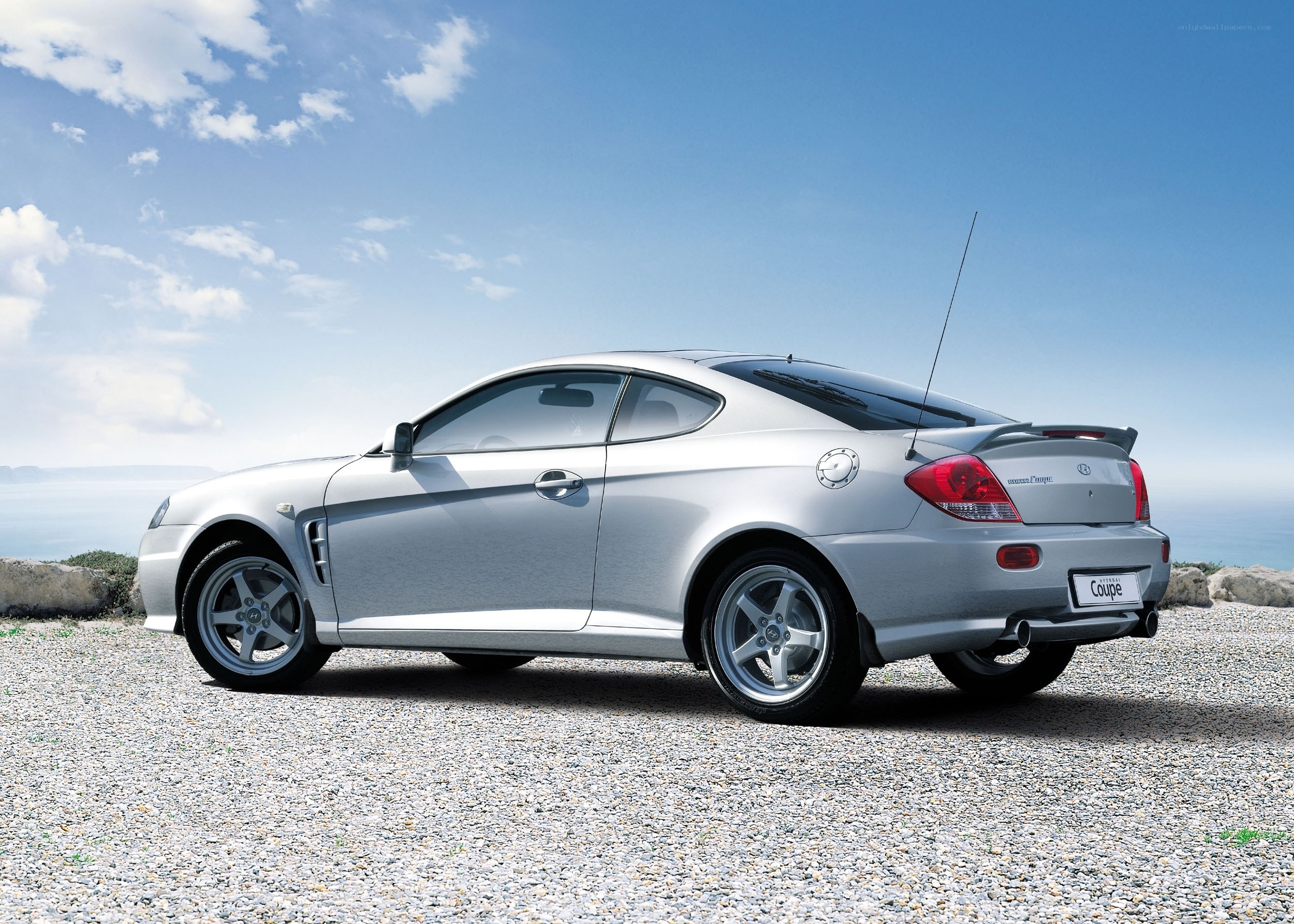 silver coupe on gravel