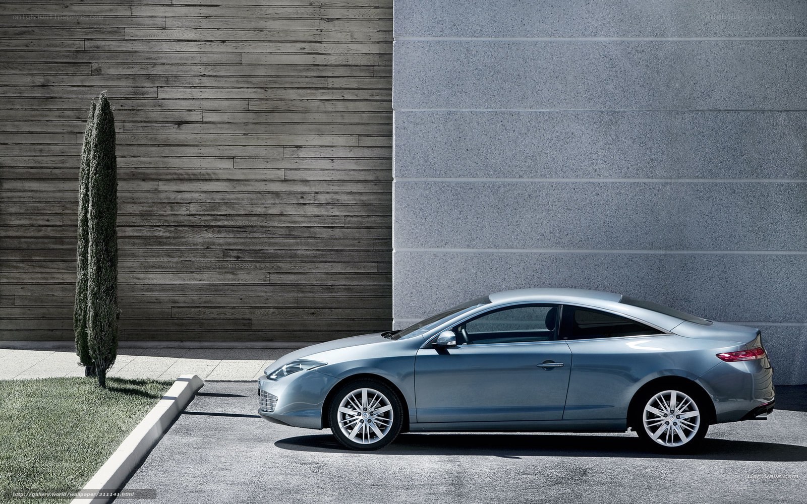 Silver coupe parked by modern wall