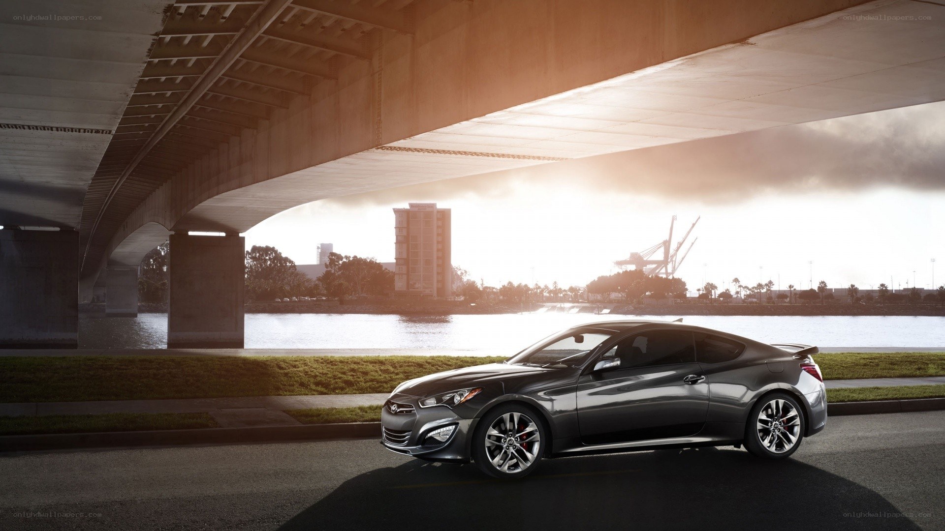 Silver coupe under a bridge
