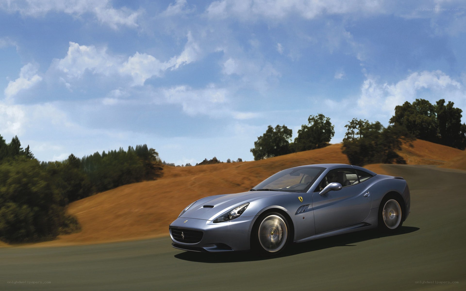 Silver Ferrari driving on a road
