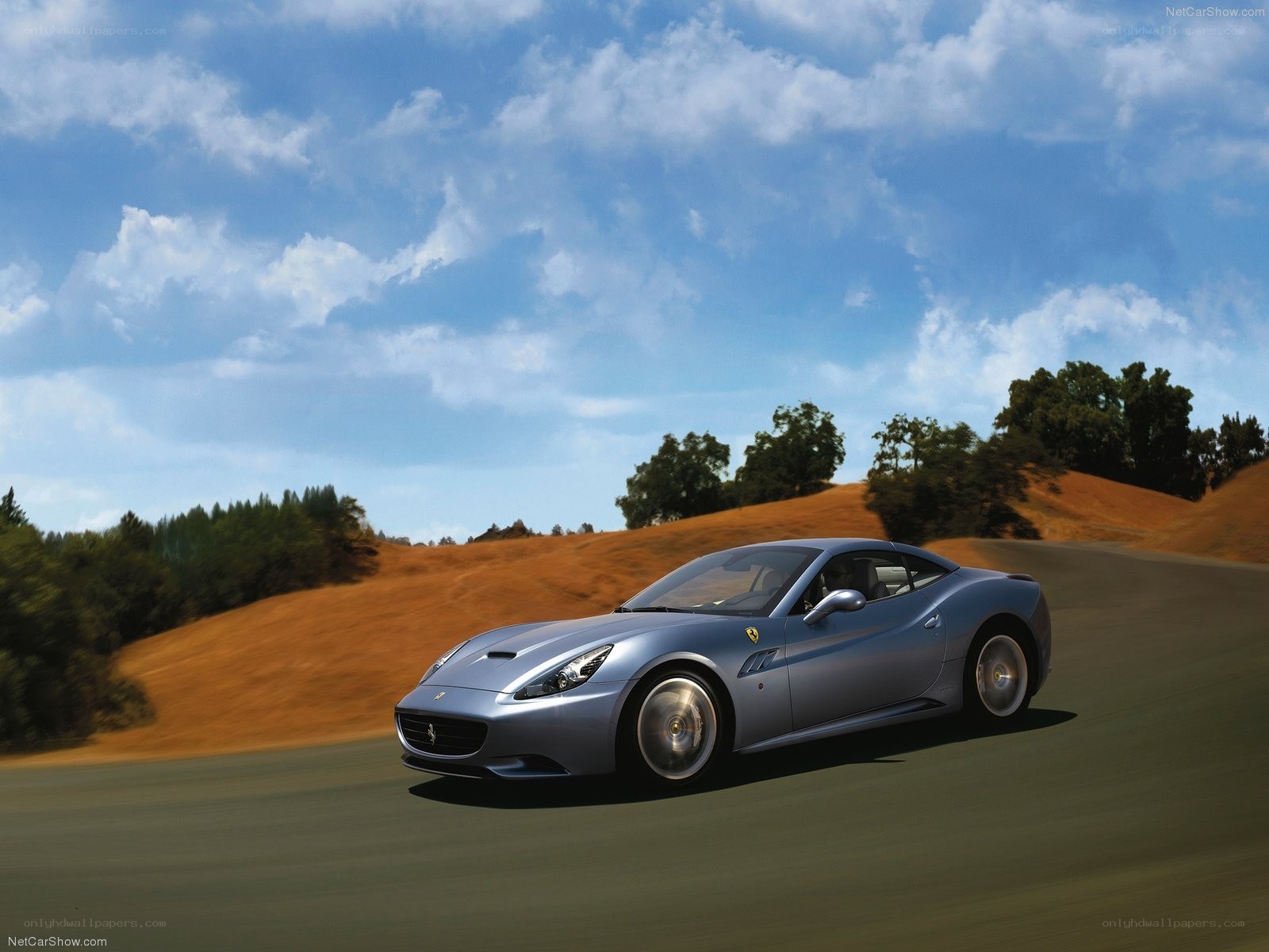 Silver Ferrari driving on a road