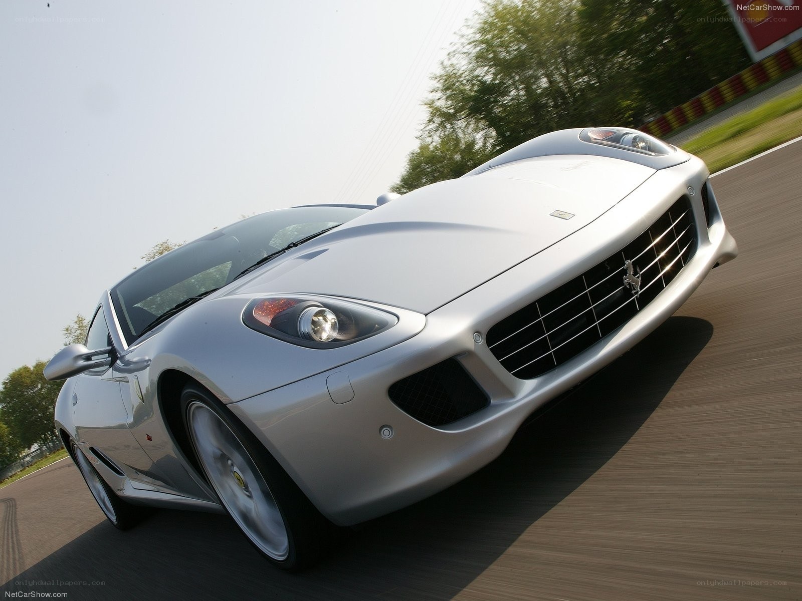 silver ferrari driving on track