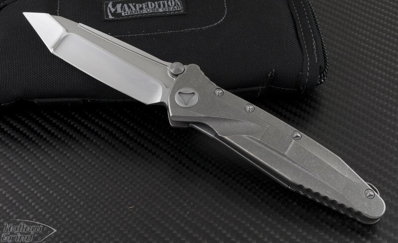 silver folding knife on black fabric
