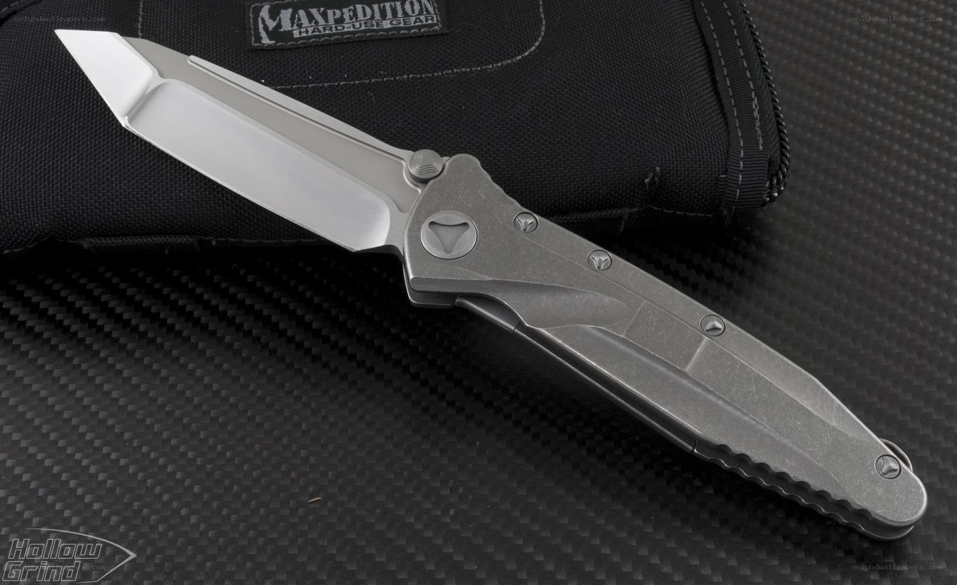 silver folding knife on black fabric