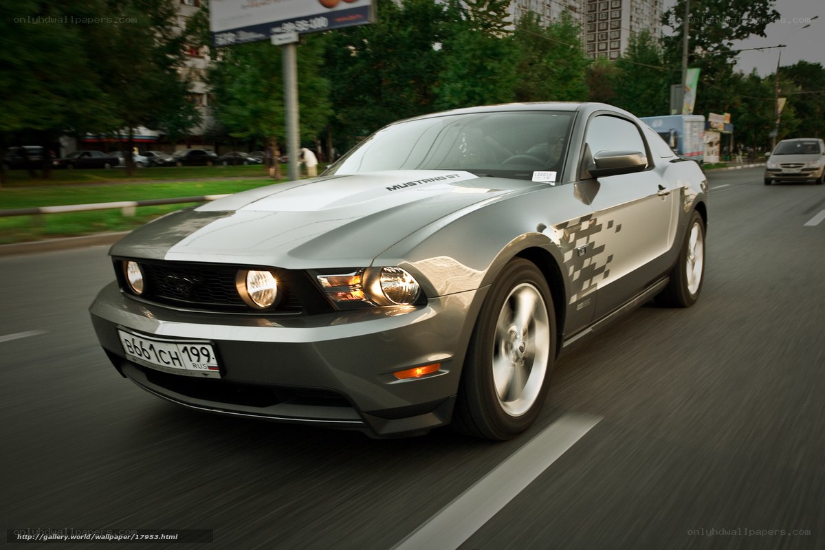 Silver Ford Mustang driving on city street