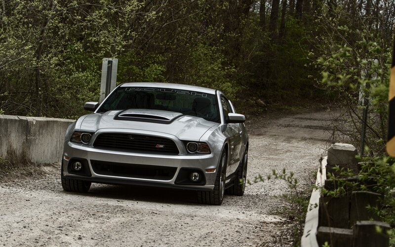 Silver Ford Mustang on a dirt road