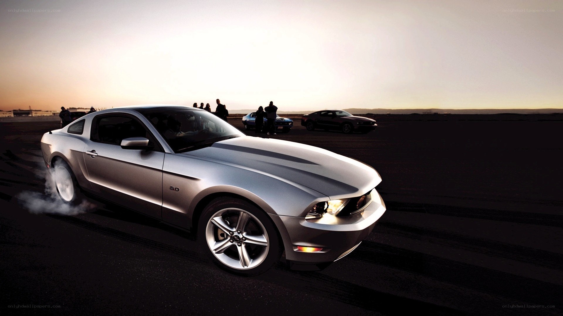 Silver Ford Mustang performing burnout