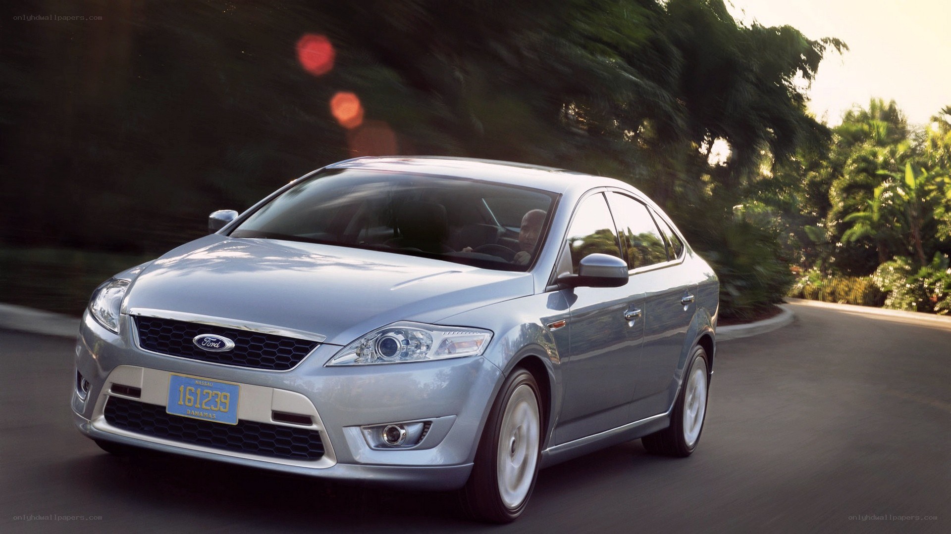 silver ford sedan on road