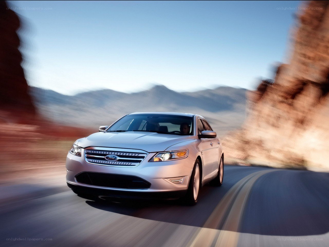 Silver Ford Taurus on a desert road