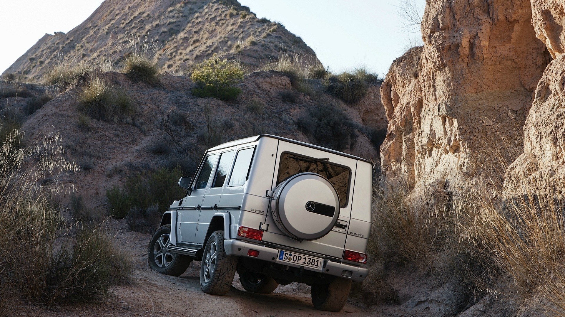 Silver G-Wagon in desert canyon