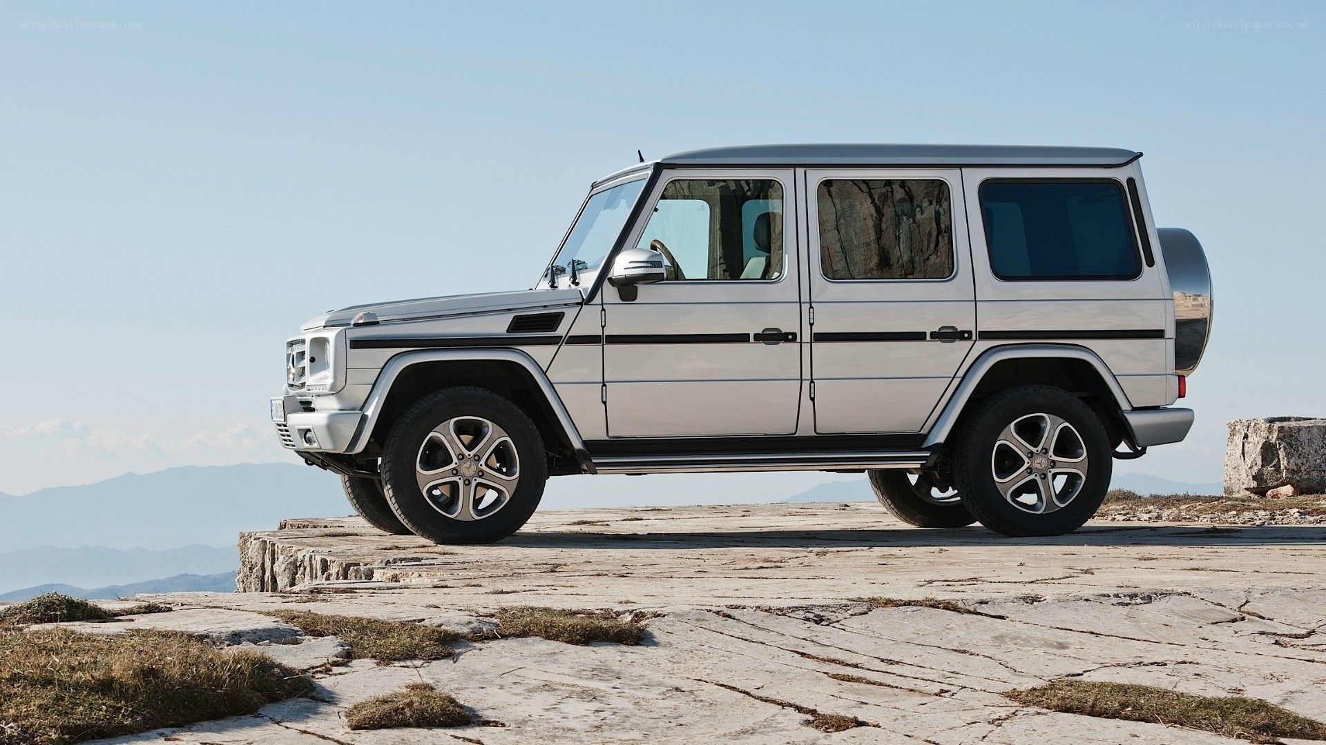 silver g-wagon on rocky cliff