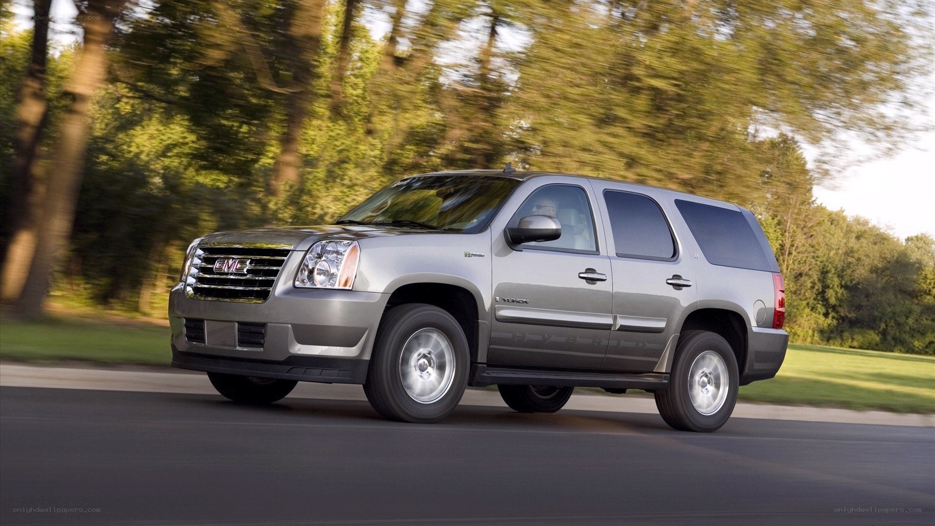 silver gmc yukon driving on road