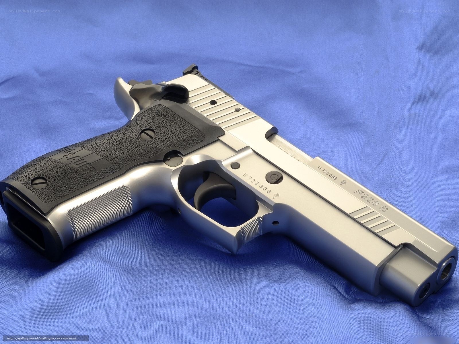 silver handgun on blue cloth